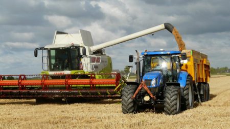 Nawożenie pól – przykry zapach blue tractor next to white farm vehicle at daytime