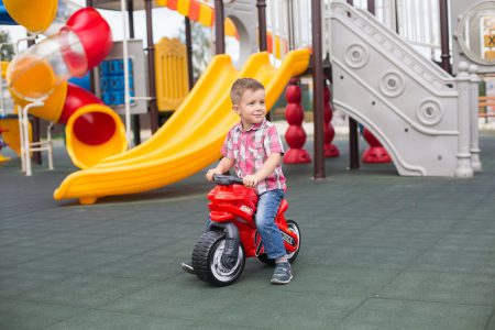 girl in pink shirt riding on red and white trike