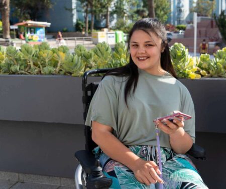młoda kobieta z niepełnosprawnością siedząca na wózku inwalidzkim